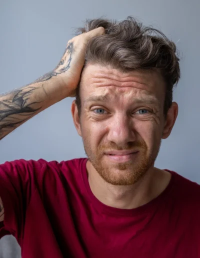Hombre con tatuajes y camiseta roja.